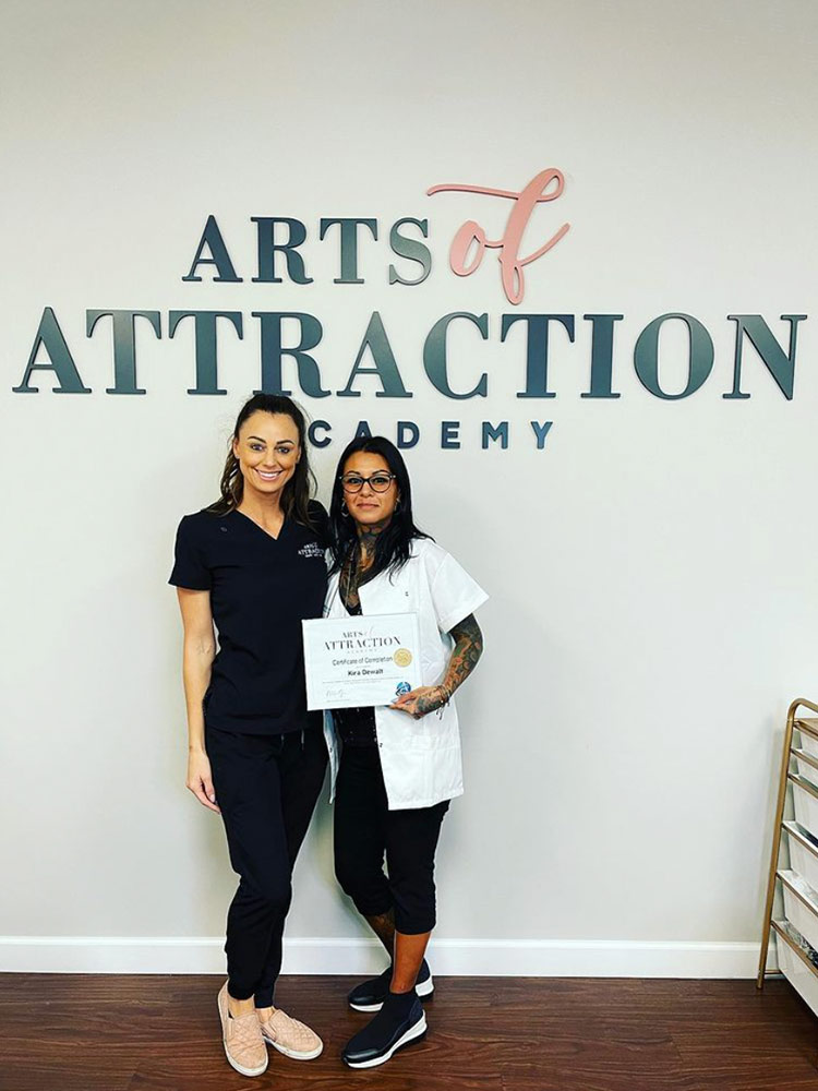 Kira DeWalt posing with colleague while holding a certificate of completion